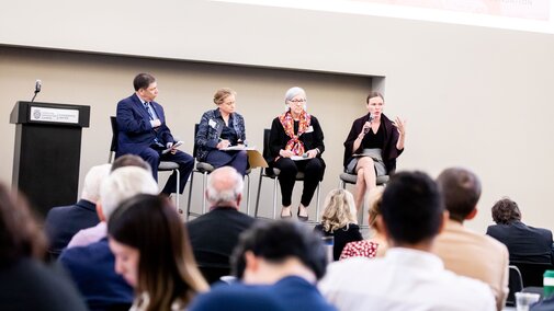 Kathleen Claussen speaking on a panel in front of audience